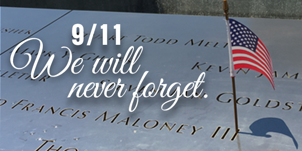 911 memorial with american flag and white script text: 9/11 We will never forget