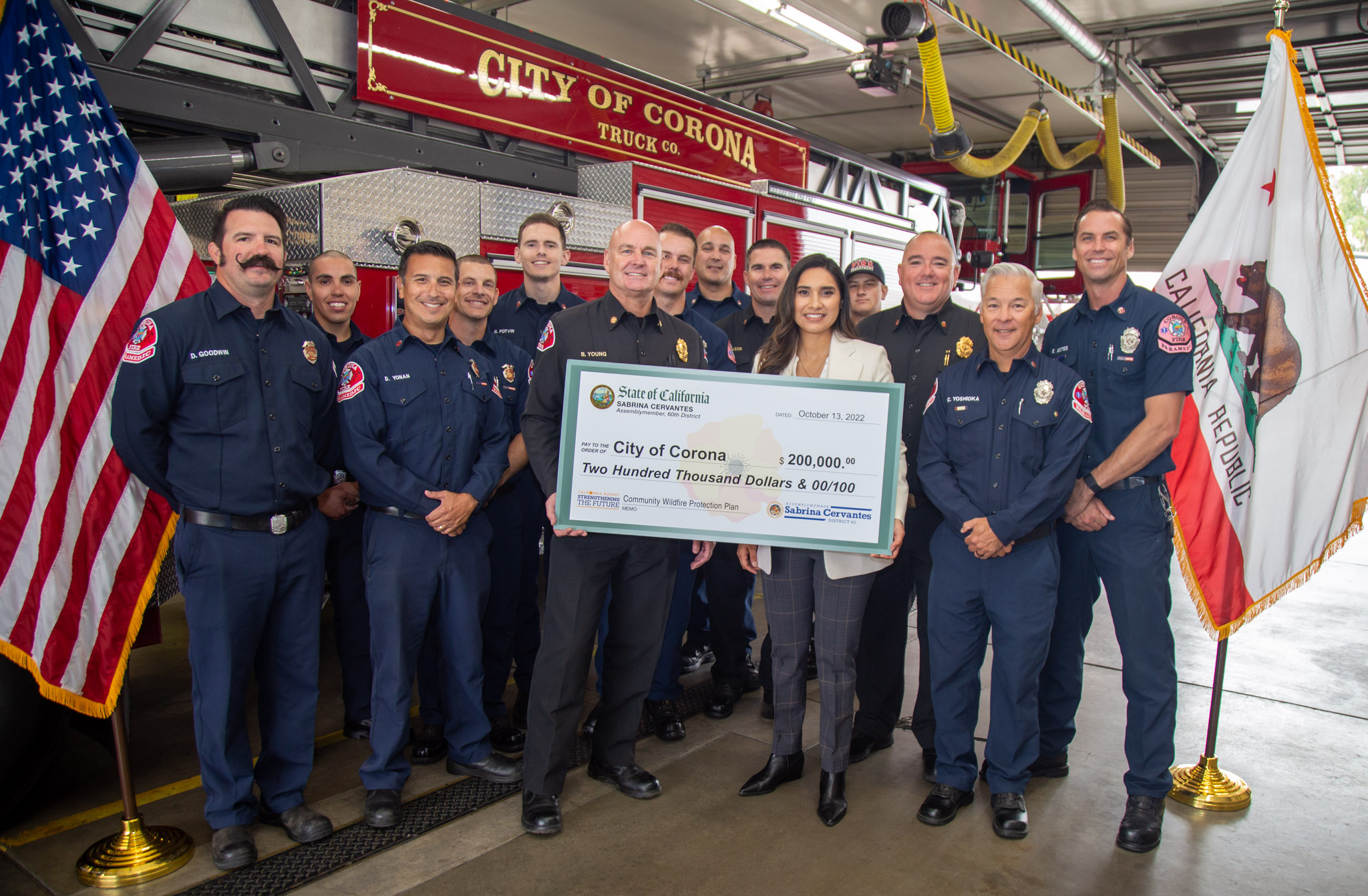 Assemblymember Sabrina Cervantes and City of Corona Firefighters and representatives holding a large oversized check of $200,000 for the City's Wildfire Safety Plan