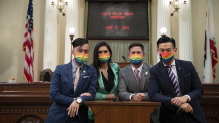 California Legislative LGBTQ Caucus Members standing at podium. From the left: Assemblymembers Alex Lee, Sabrina Cervantes, Chris Ward, and Evan Low